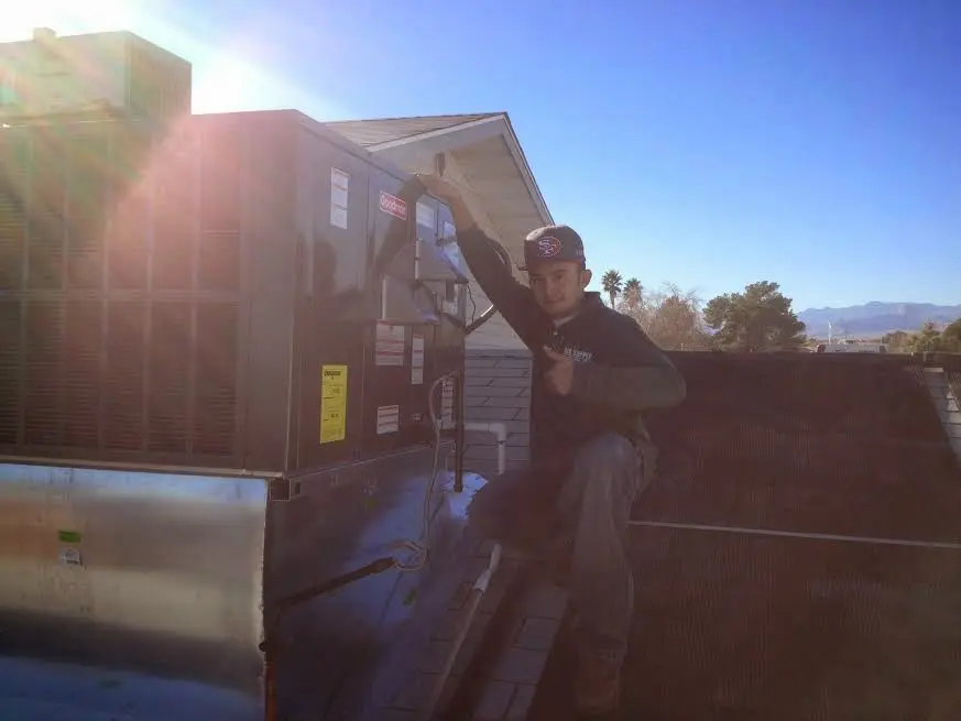 HVAC technician performing Air Duct Cleaning on a rooftop unit in Ettrick